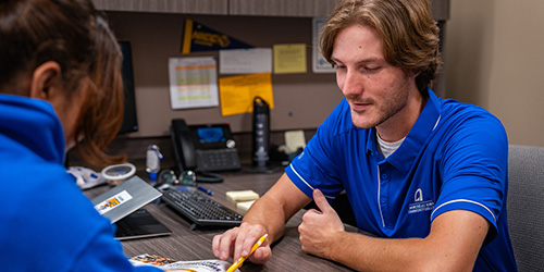 An admissions rep talks with a student.