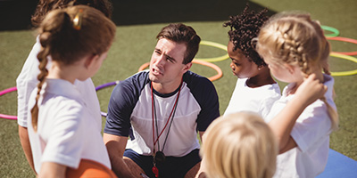 A coach speaking to a group of young athletes