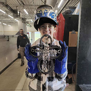 A young male camper showing off his welding project