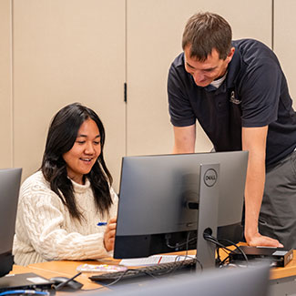 Female business student getting help in computer lab