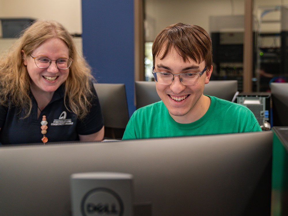 Male student and instructor working at a computer