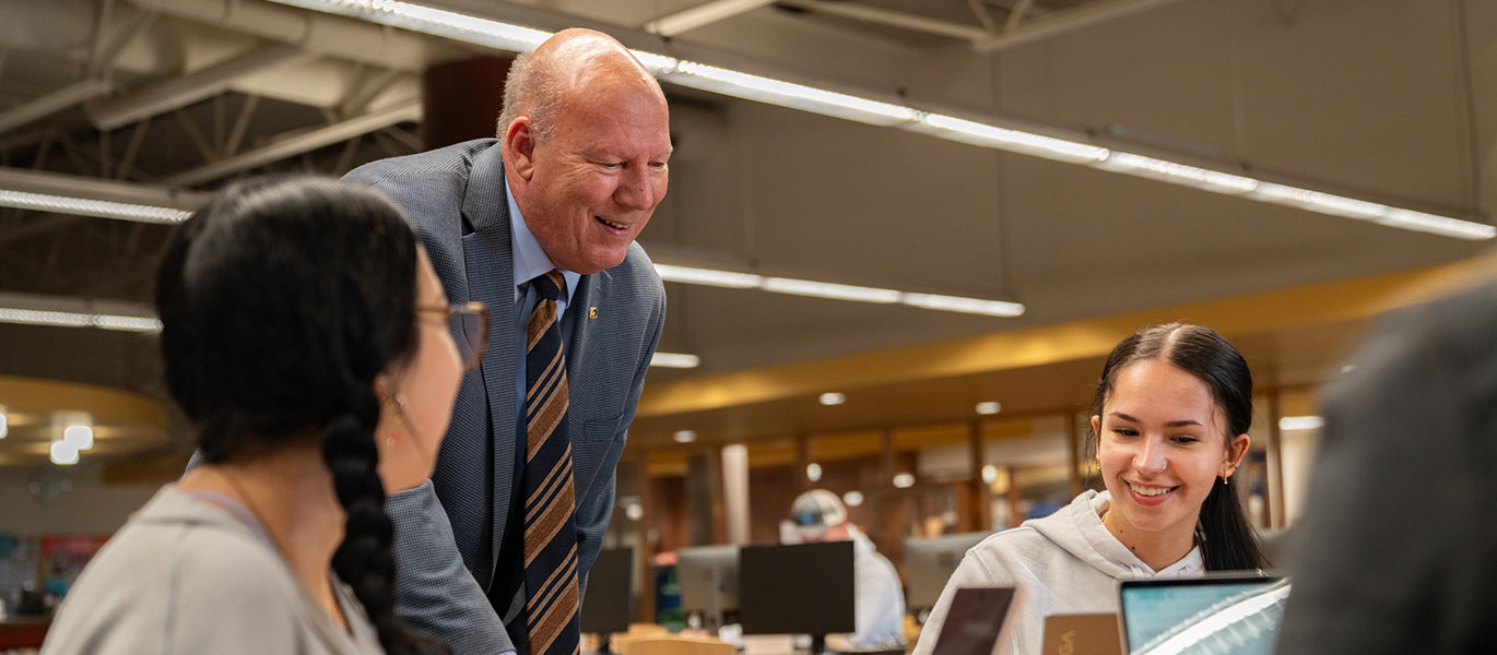 Dave Dahms having a conversation with students in the library